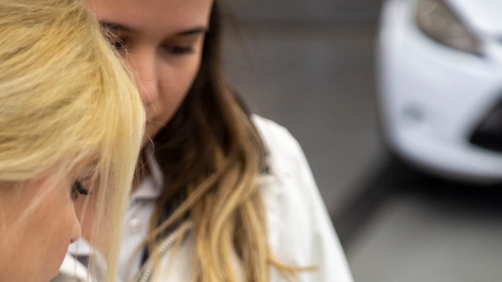 KFZ-Sachverständiger mit Klemmbrett bei der Begutachtung eines Fahrzeugs